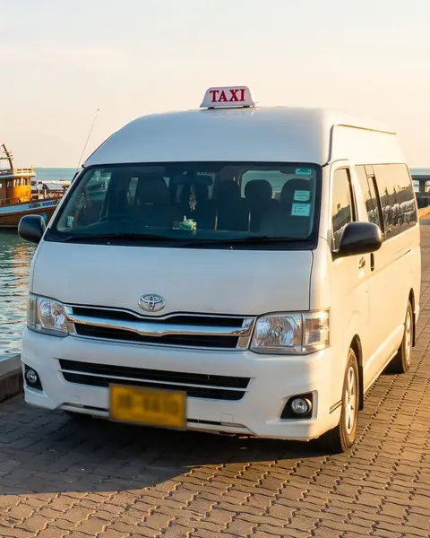 Taxi van parked on the quay at Ban Phe pier, with boats for Koh Samet behind it